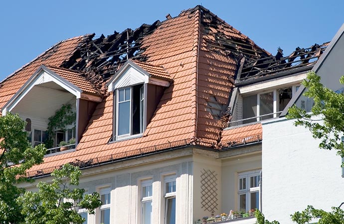 Fire-damaged roof in Katy, Texas being secured by emergency roofers
